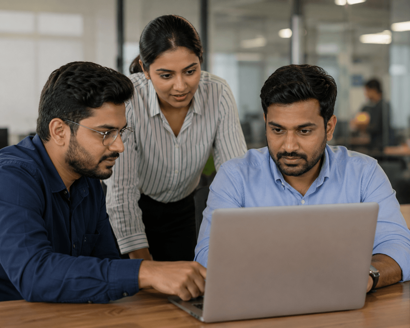 Small service company team meeting around a laptop reviewing a client quotation