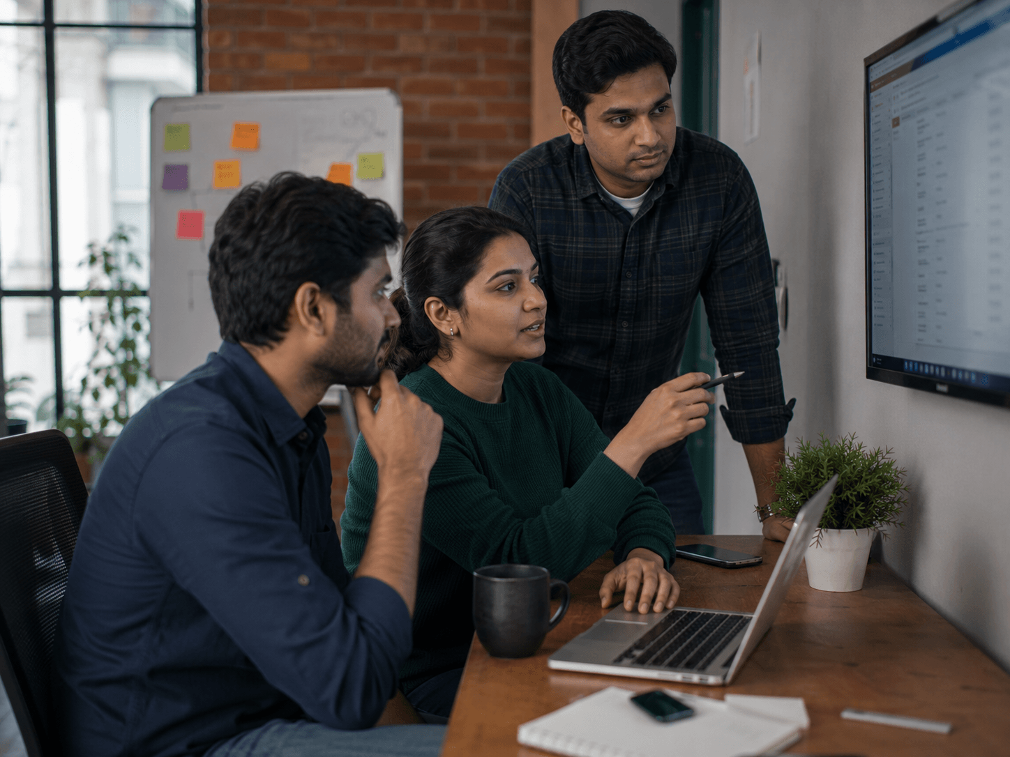 Small tech team reviewing a client invoice or project milestone